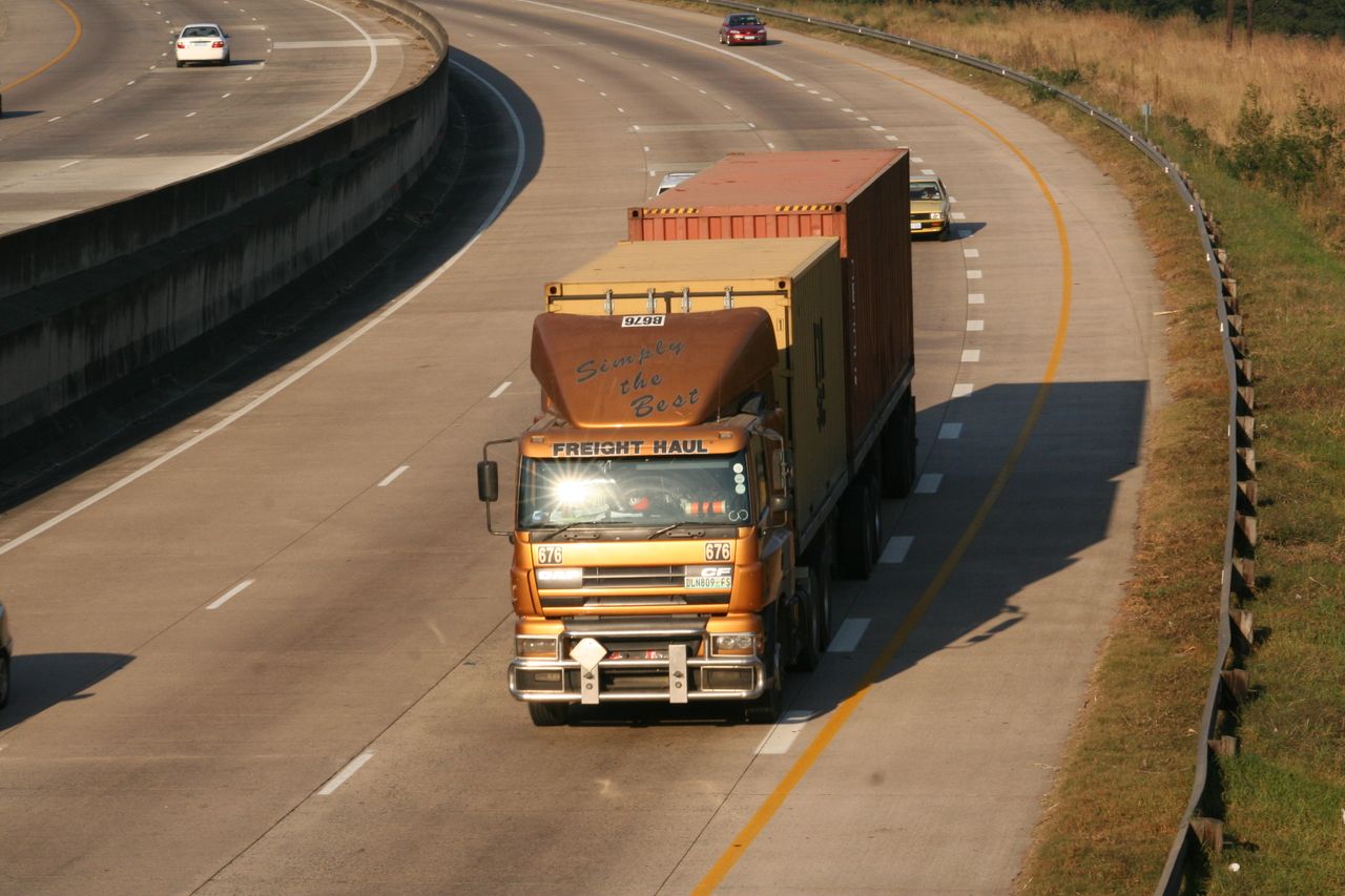 gallery-6 Cargo truck navigating a highway, aerial view on Dolphin Coast, South Africa.
