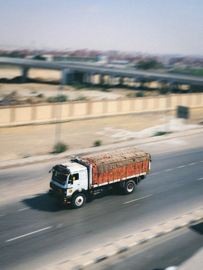 why-choose-us A cargo truck swiftly travels on a highway, emphasizing logistics and speed.