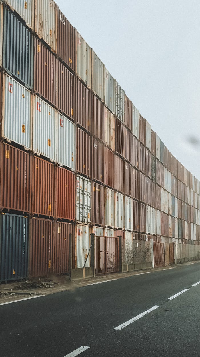 gallery-3 High-rise stack of shipping containers along an industrial road in foggy weather.