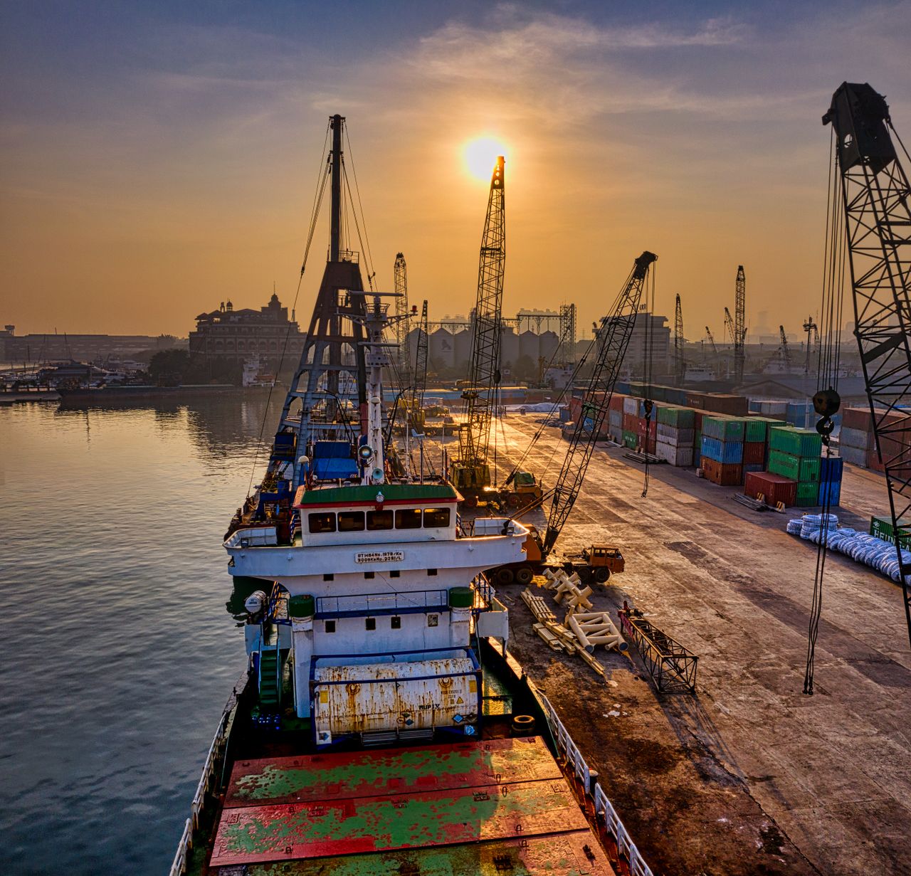 contact-img A vibrant scene of cargo operations during sunrise at a busy port in Indonesia.
