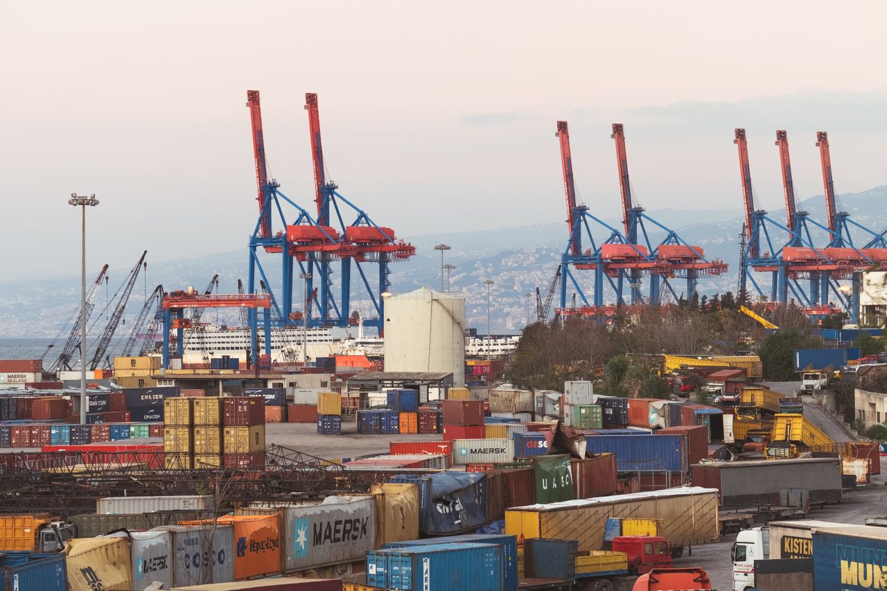 gallery-4 A bustling industrial view of Beirut port with cargo containers and towering cranes.